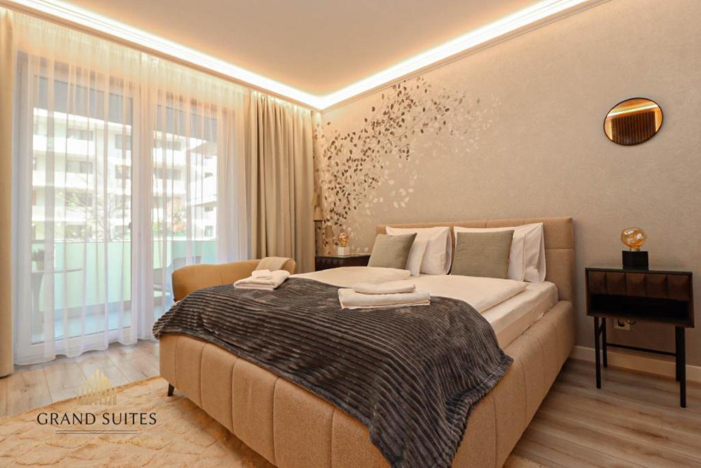 a bedroom with a large bed and a desk at Grand Suites Promenade in Budapest