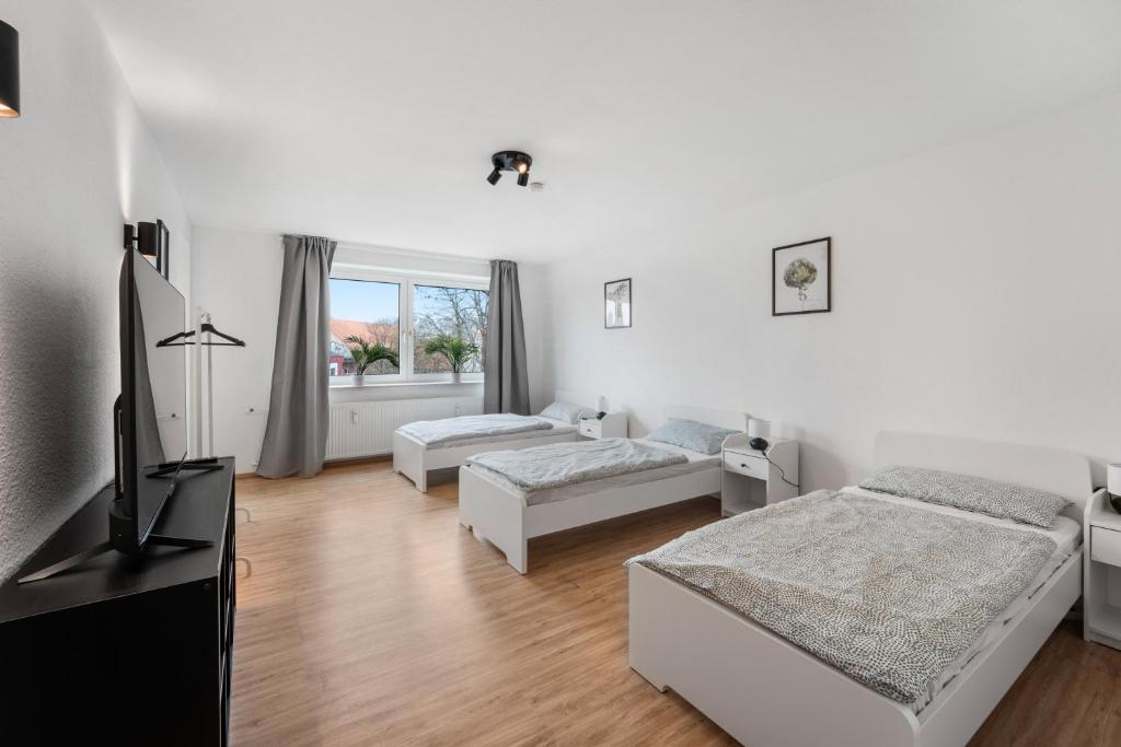 1 dormitorio con 2 camas y TV de pantalla plana en Modernes Apartment mit Balkon, en Brunswick