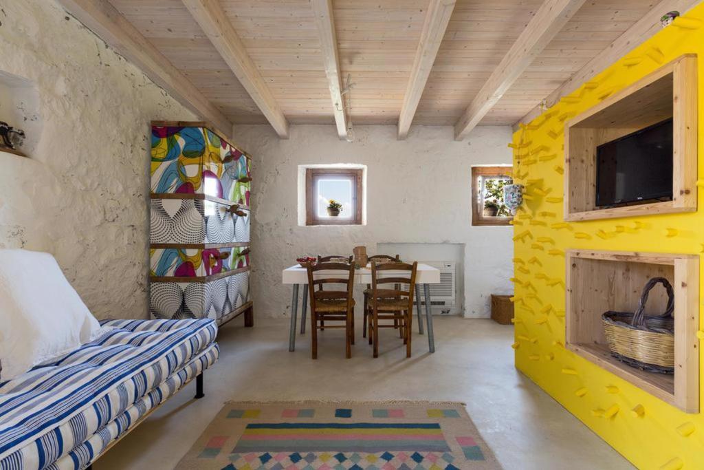 een kamer met een tafel en een eetkamer bij Trullo Salento in Corigliano dʼOtranto