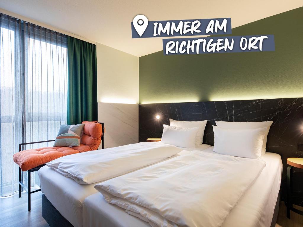 Habitación de hotel con cama y silla en ACHAT Hotel Stuttgart Airport Messe, en Stuttgart