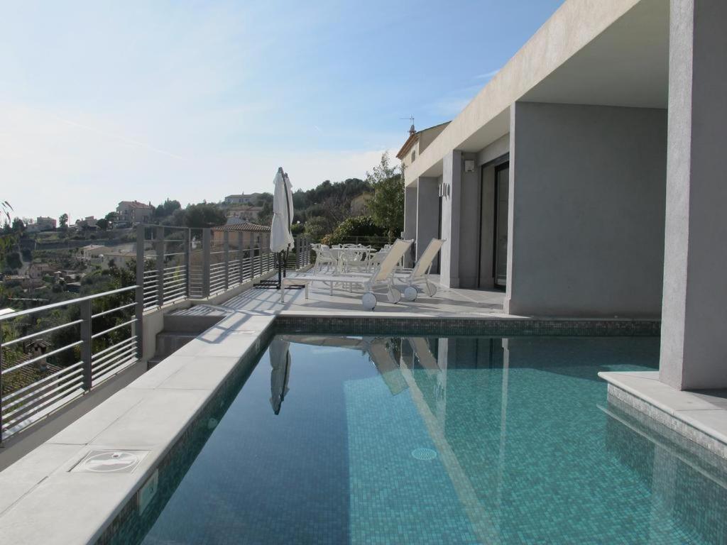 a swimming pool with chairs and an umbrella on a building at Villa 5* Nice St Pancrace in Nice