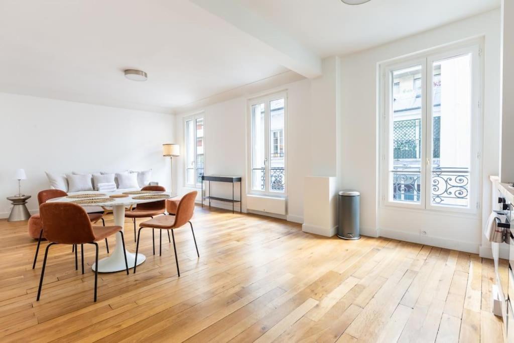 uma sala de estar com mesa e cadeiras em Invalides - Rénové - Luxe em Paris