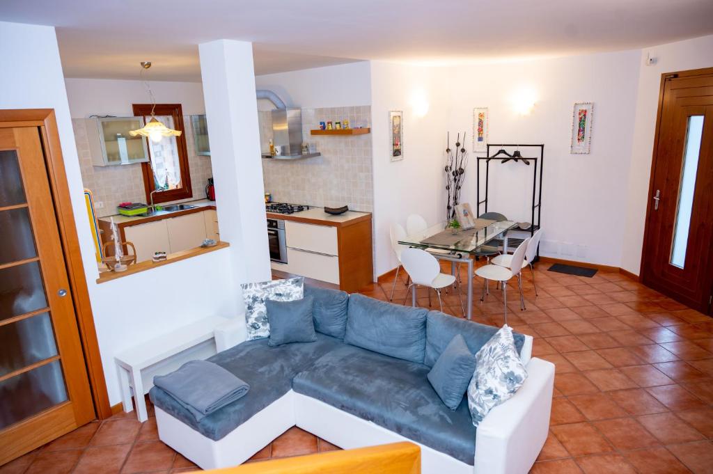a living room with a couch and a kitchen at Residence Stradella Verde in Staranzano