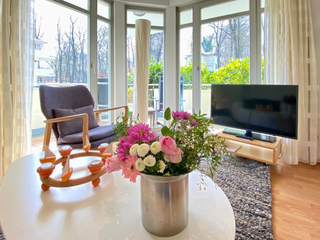 a living room with a vase of flowers on a table at Residenz Bleichröder - Ferienwohnung 13 in Neuhof