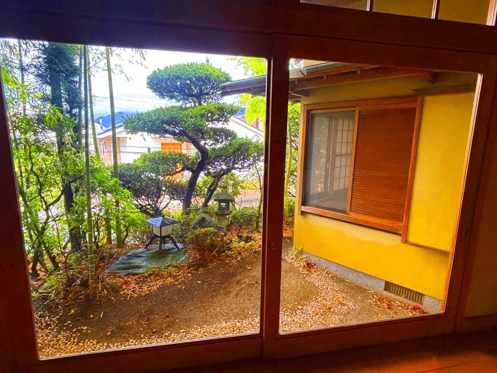 una ventana con vistas a un árbol en el exterior en 富士吉田かつまたや, en Fujiyoshida