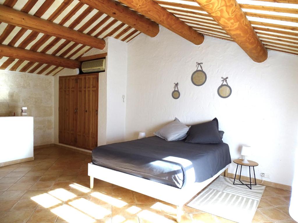 sypialnia z łóżkiem w pokoju z drewnianym sufitem w obiekcie Logement charme provençal w mieście Cabannes