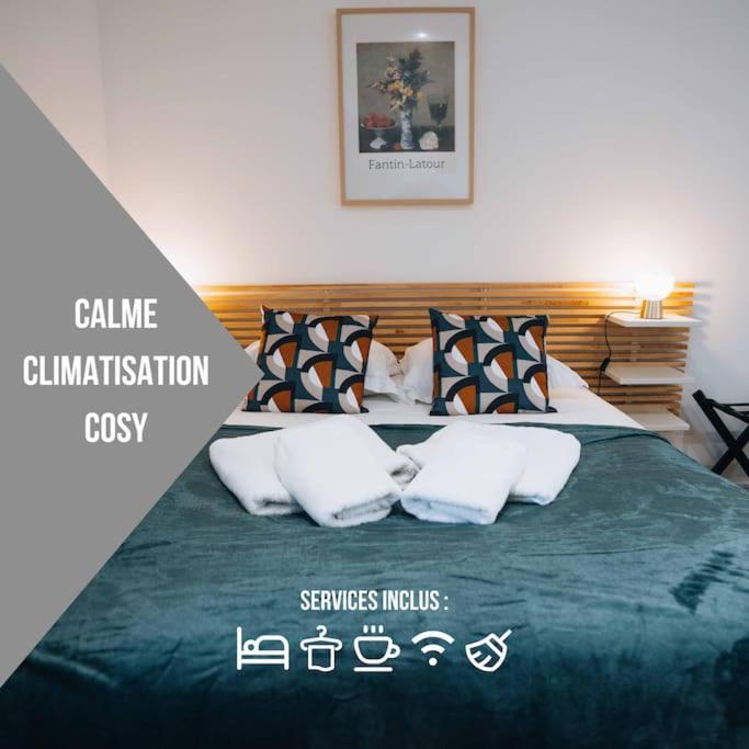 - une chambre avec un lit doté d'une couverture verte et d'oreillers dans l'établissement L'Atelier du Peintre • L'inattendu en centre-ville, à Châteauroux