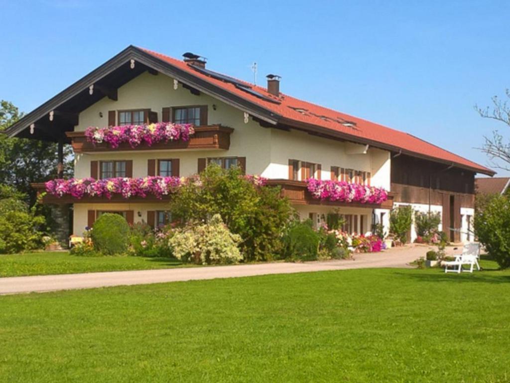 Una casa grande con flores al costado. en Huberhof, en Riedering