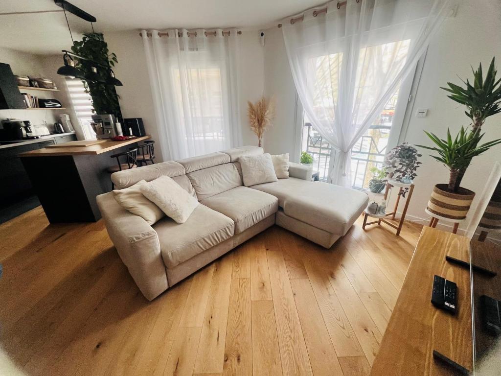 ein Wohnzimmer mit einem weißen Sofa und Holzböden in der Unterkunft JO Paris 2024 in Saint-Ouen
