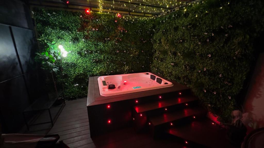 By nuit-parisienne : Superbe appartement avec SPA et terrasse privée في فيلومومبل: طاولة بينج بونغ أمام تحوط أخضر