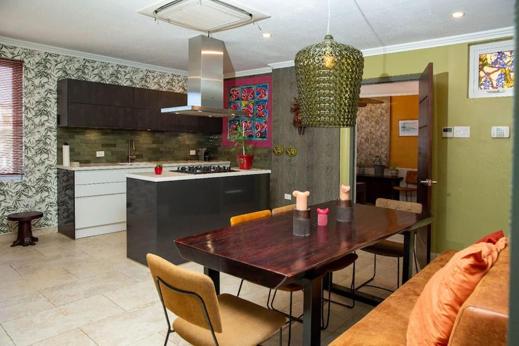 a kitchen and dining room with a wooden table and chairs at Executive apartment - Oranjestad in Oranjestad