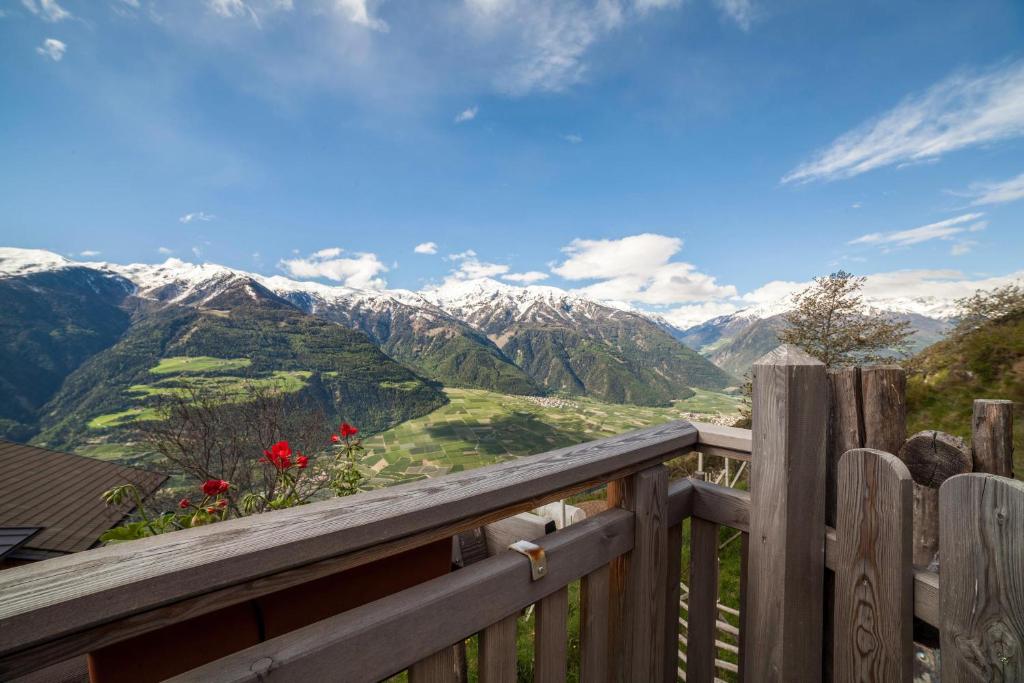 a view of the mountains from a wooden balcony at Flatschhof - Apartment Cevedale in Kastelbell-Tschars