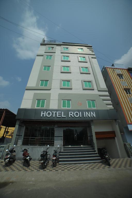 un bâtiment d'hôtel avec des motos garées devant lui dans l'établissement HOTEL ROI INN, à Tirupati