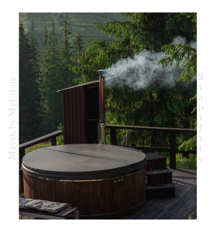 a hot tub with smoke coming out of it on a deck at Aparthotel "Mayak Yablunytsia" in Yablunytsya