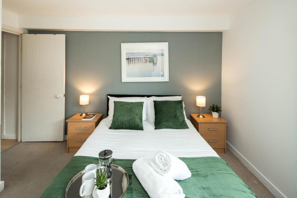 a bedroom with a large white bed with green sheets at Lovely one bed flat London Bridge in London