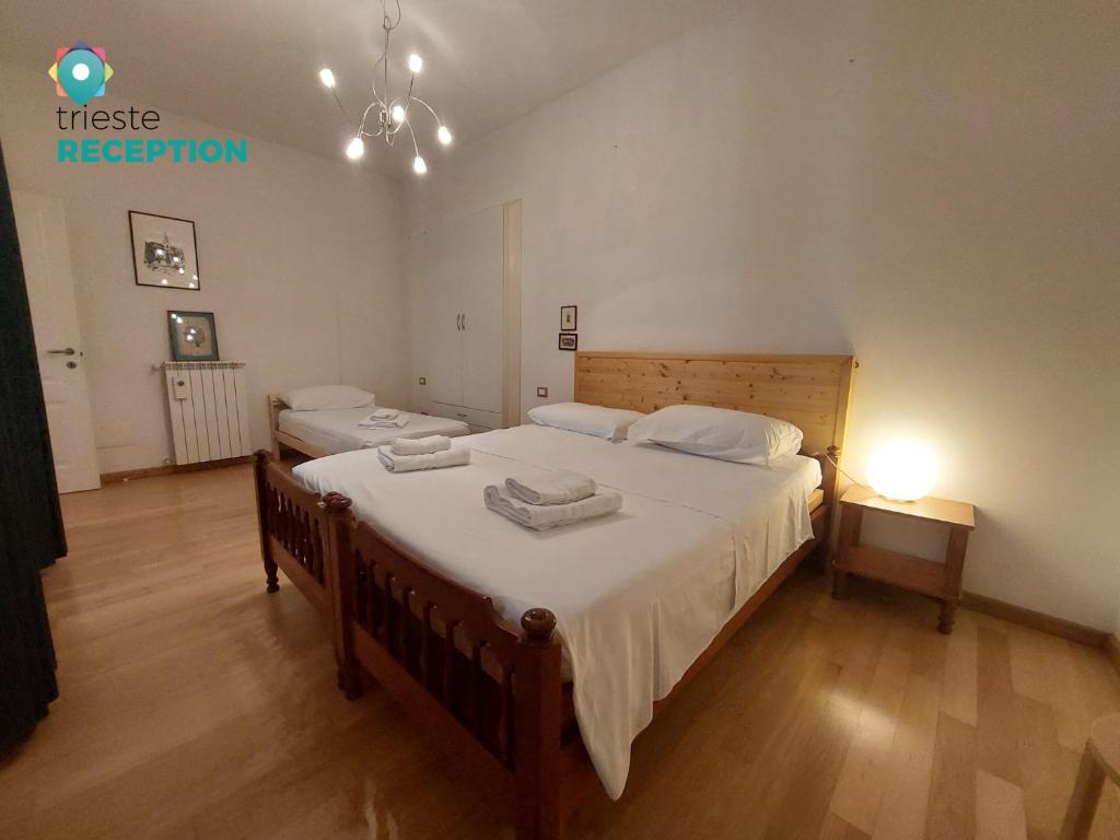 1 dormitorio con 1 cama con 2 toallas en La Terrazza, en Trieste