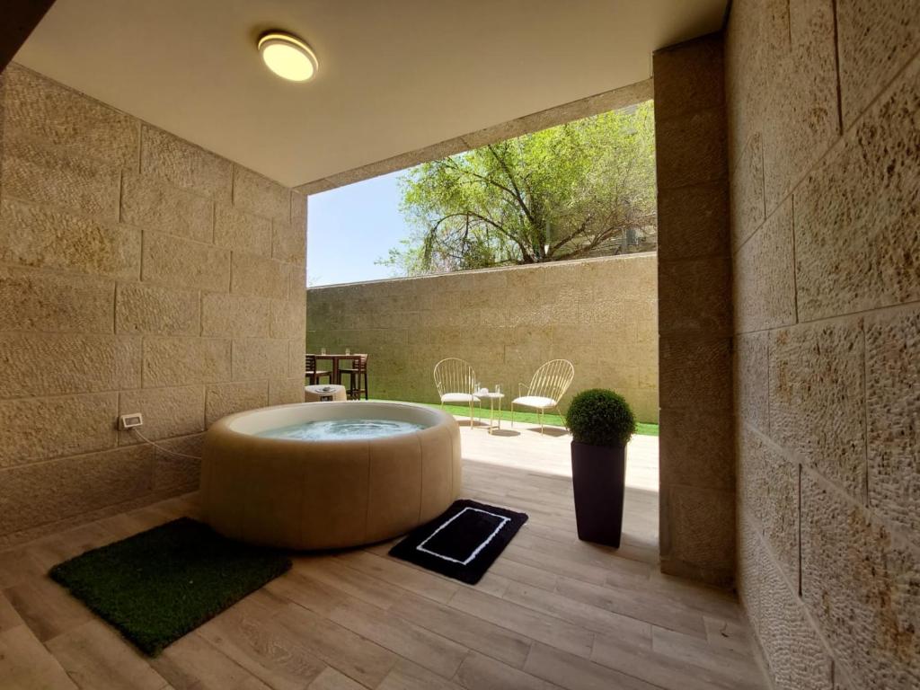 a bathroom with a large round tub in a room at צ'יל ורוגע עם ג'קוזי וגינה פרטית in Bayit Wegan