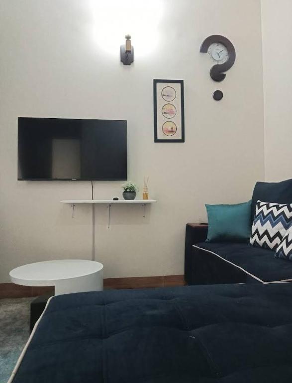 a living room with a couch and a table and a tv at Riverside Apartments in Buwate