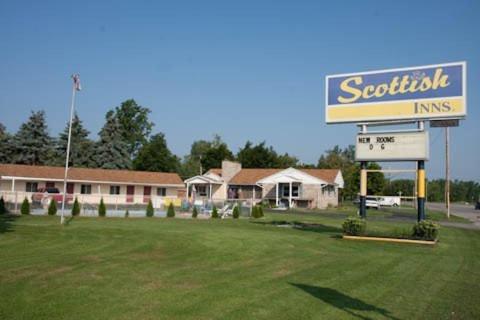 a sign for a scientologist inn in front of a building at Scottish Inn - North Tonawanda in Tonawanda