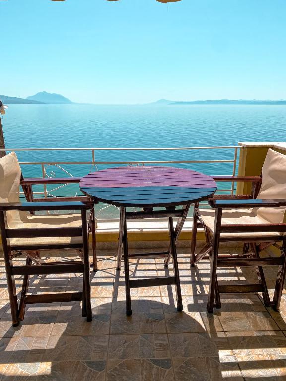 una mesa y 2 sillas en un balcón con vistas al océano en Evilion studios, en Ilia