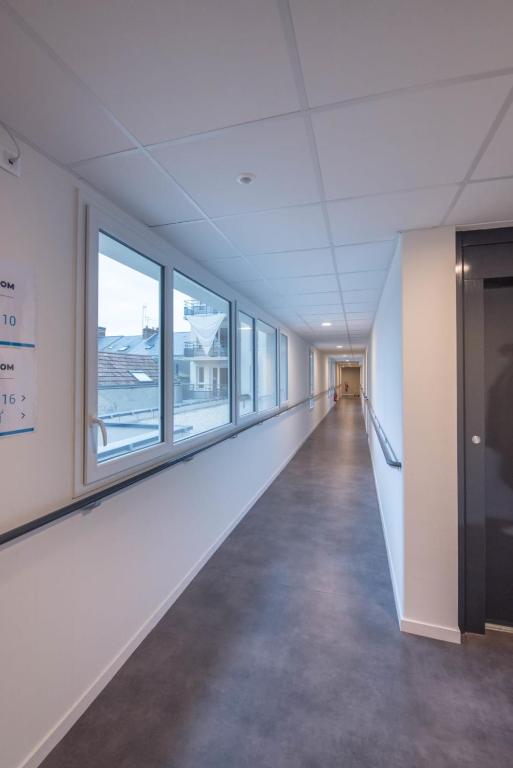 an empty hallway in an office building with windows at Elodie - T2 proche gare in Le Mans