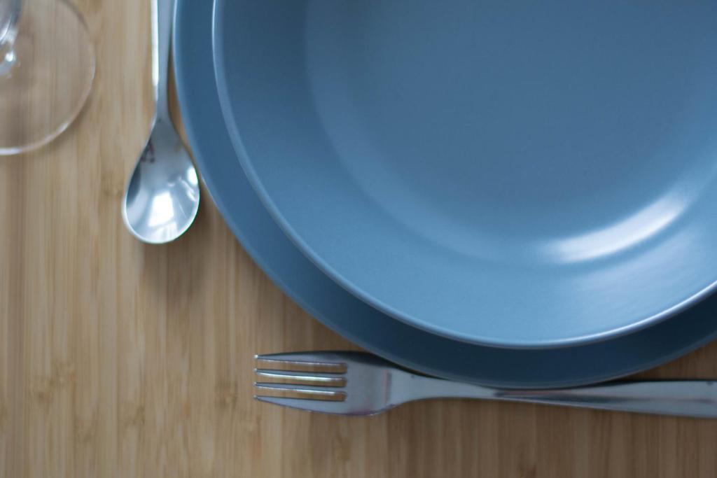 a blue plate and a fork on a table at Elodie - T2 proche gare in Le Mans