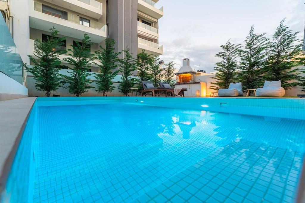 una piscina azul frente a un edificio en Speiō Luxury House, en Heraclión