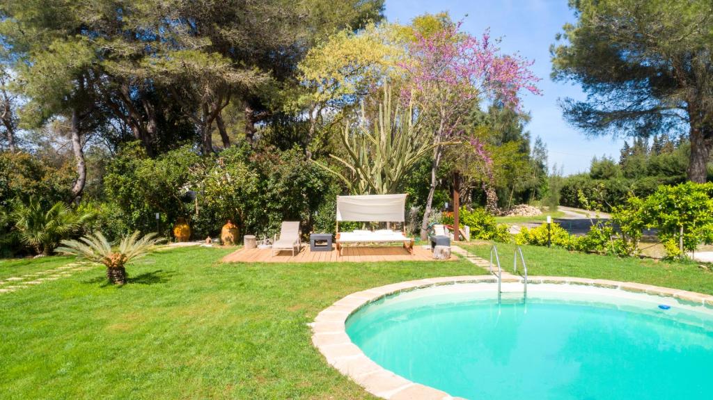 una piscina in un cortile con panchina di Dèpendance - Lequile - Alfa Country House a Lequile