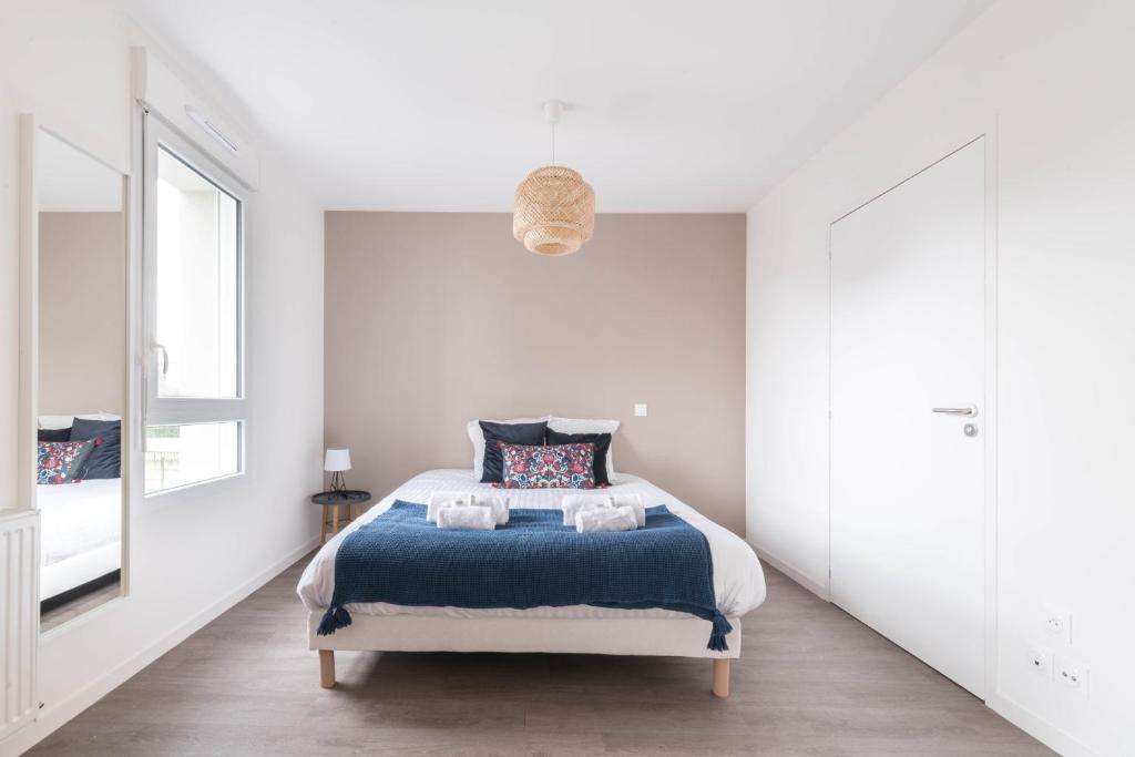 a white bedroom with a bed and a window at Pierrick - Studio wifi et gare in Le Mans