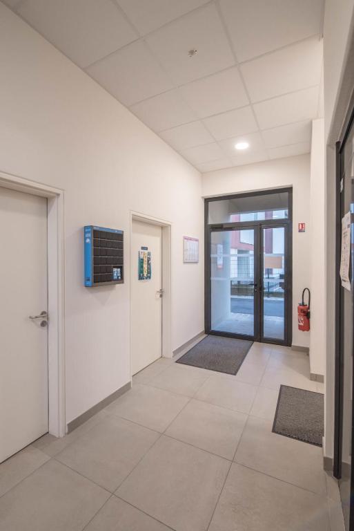 an empty hallway of an office with doors and rugs at Pierrick - Studio wifi et gare in Le Mans