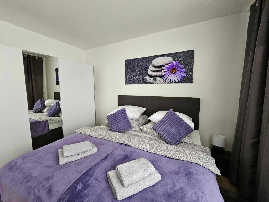 a bedroom with a purple bed with towels on it at Slunný byt v klidné části Hradce Králové - zahrada, parkování zdarma in Hradec Králové