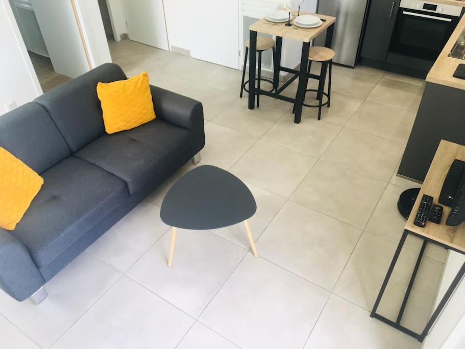 un salon avec un canapé bleu et une table dans l'établissement La p’tite Escale des Brias - L’escale des Brias, à Saint-Martin-Lacaussade