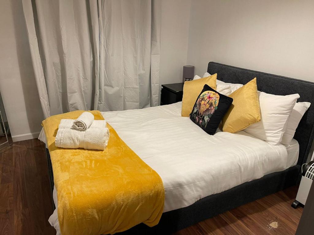 una camera da letto con un grande letto con lenzuola e cuscini gialli di SAV 1 Bed Apartment Argyle Watford a Watford