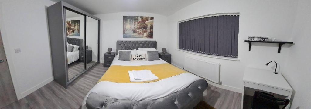 a bedroom with a bed with a yellow blanket at SAV Apartments Leicester - 2 Bed Cosy Flat Saffron in Leicester