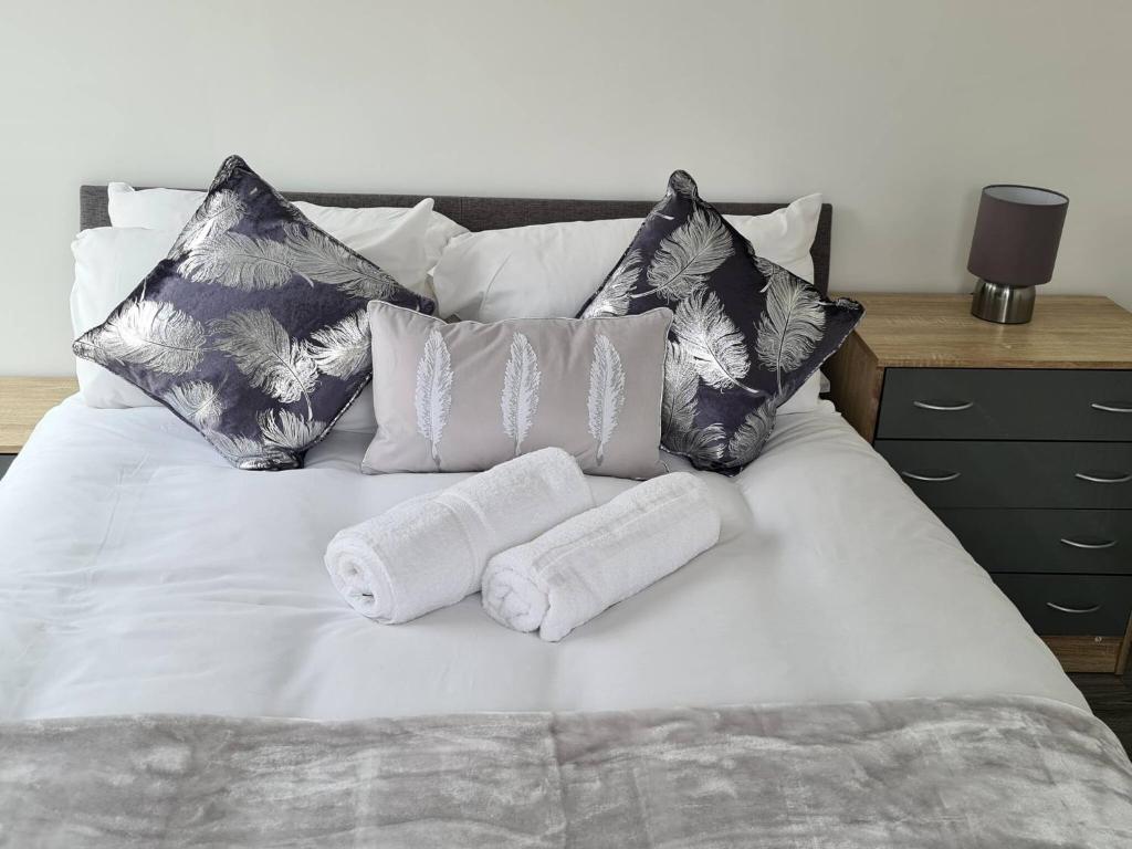 een bed met twee handdoeken en kussens erop bij SAV Apartments Nottingham Road Loughborough - 1 Bed Flat in Loughborough
