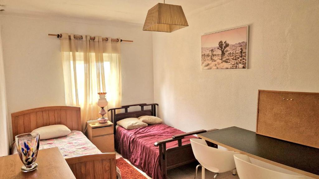 Zimmer mit 2 Betten, einem Tisch und Stühlen in der Unterkunft AL Famalicão in Leiria