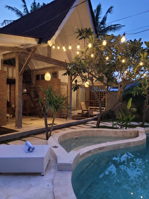 een zwembad voor een huis met verlichting bij Amara Villa in Gili Trawangan