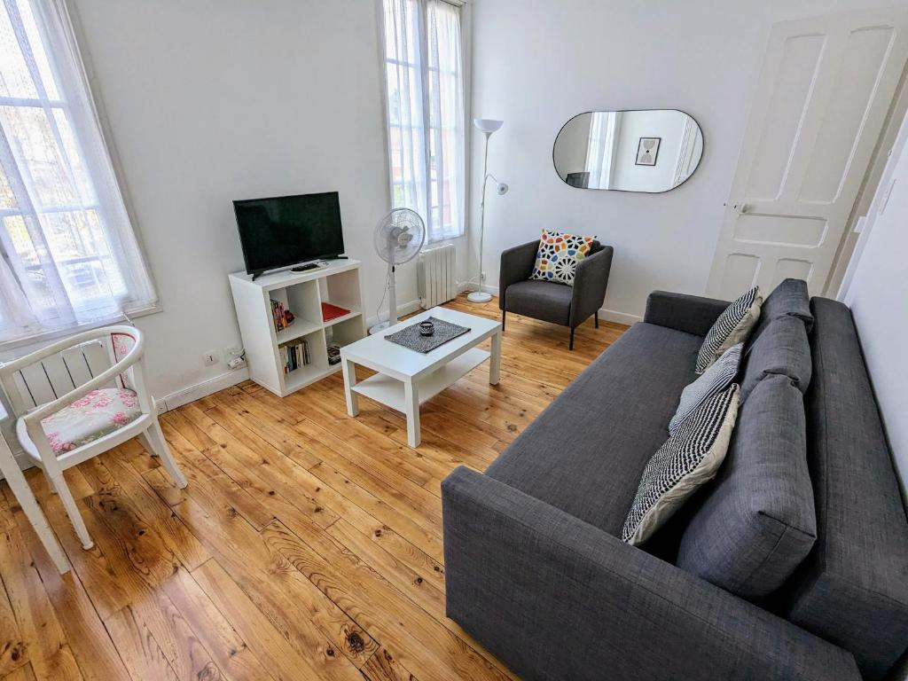 sala de estar con sofá y TV en T2 42 m² en Centre-ville de Cambo-les-Bains, en Cambo-les-Bains