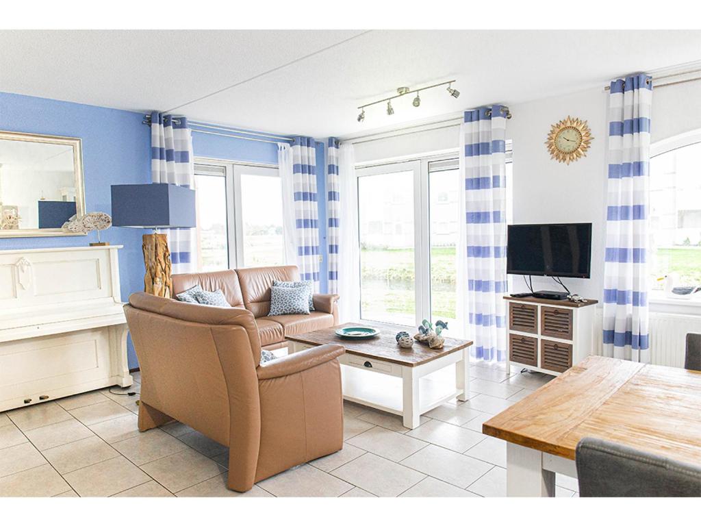 a living room with a couch and a tv at Residence Juliana 68 in Julianadorp