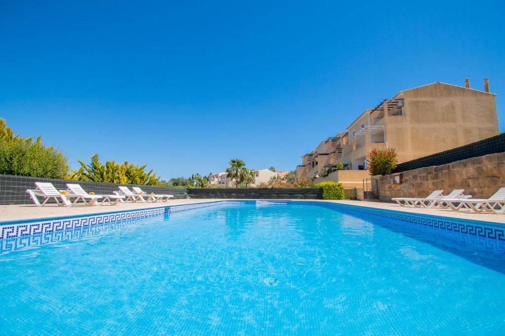 a large swimming pool with chairs and a building at Casa Kantara in Ferragudo