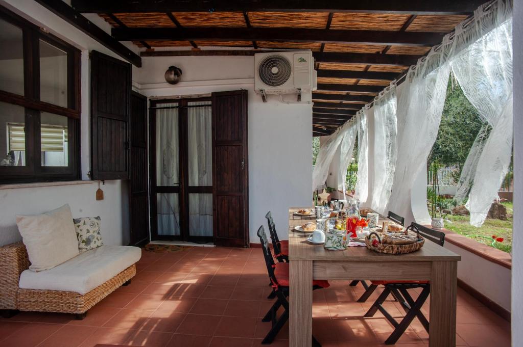 Habitación con mesa, sillas y sofá en Sardinia Del Sud, en Porto Columbu - Perdʼe Sali