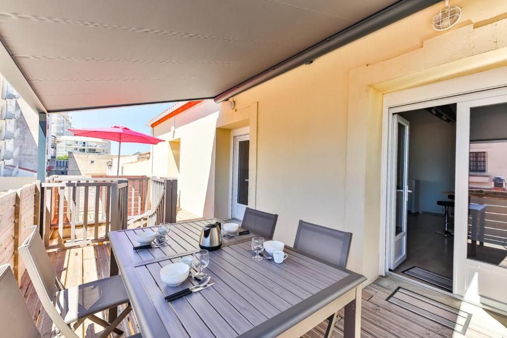 una mesa de madera en el balcón de una casa en Côté Plage - Appartement 100m vue mer, en Saint-Jean-de-Monts