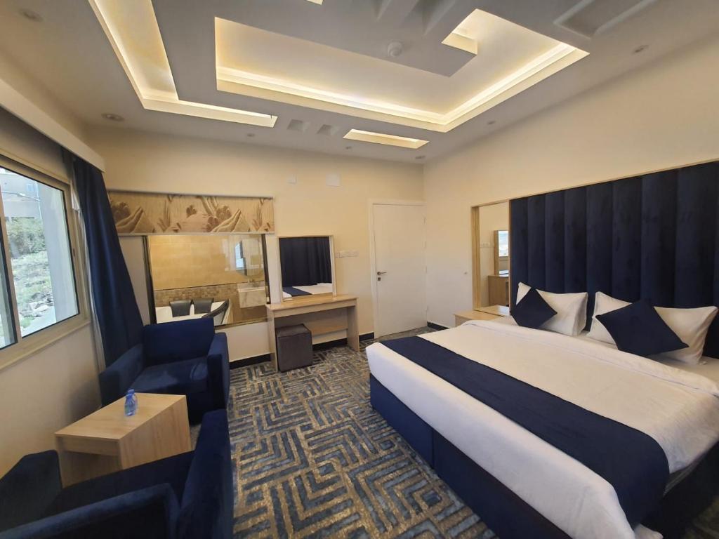 Habitación de hotel con cama extragrande y escritorio. en سلافا للشقق أبها en Abha
