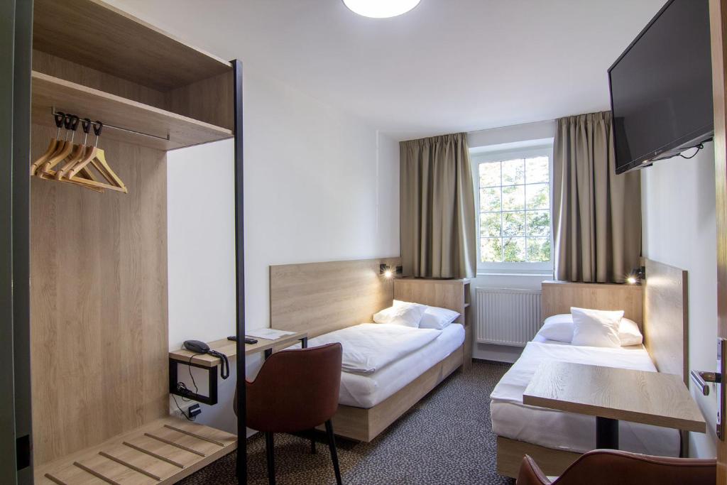 ein Hotelzimmer mit 2 Betten und einem Schreibtisch in der Unterkunft Hotel Avion in Prag