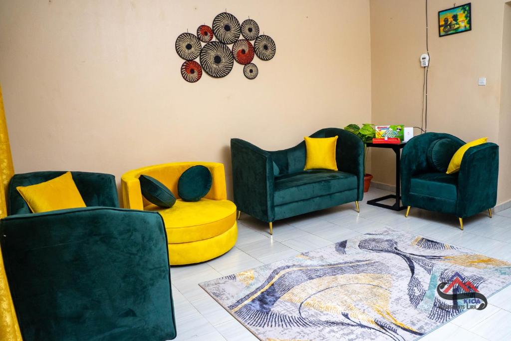 a living room with three chairs and a table at Kica Apartment with Airconditioned bedrooms in Lira, Uganda in Lira