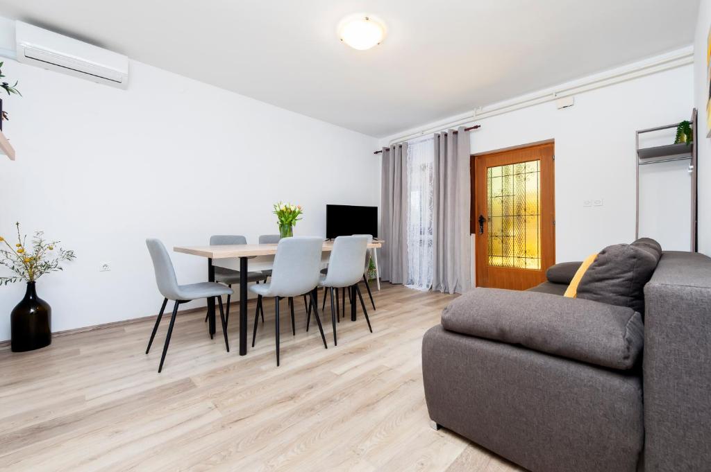 a living room with a couch and a table and chairs at Apartments Relax in Rovinj