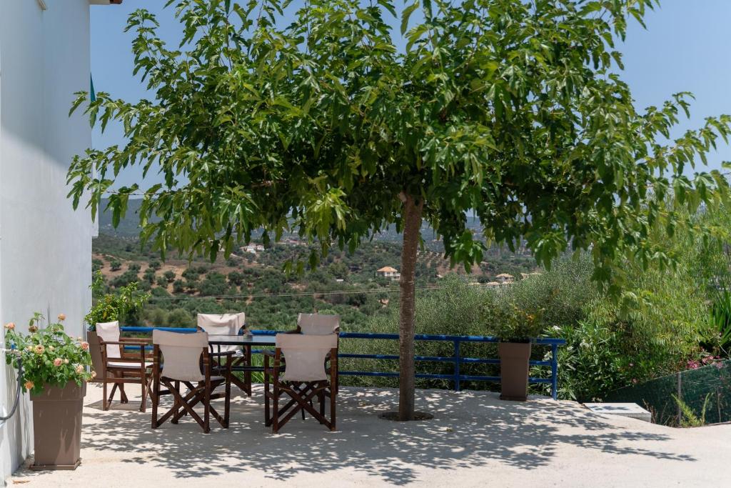 a table and chairs under a tree in a yard at Blue Houses Maisonettes in Kamária