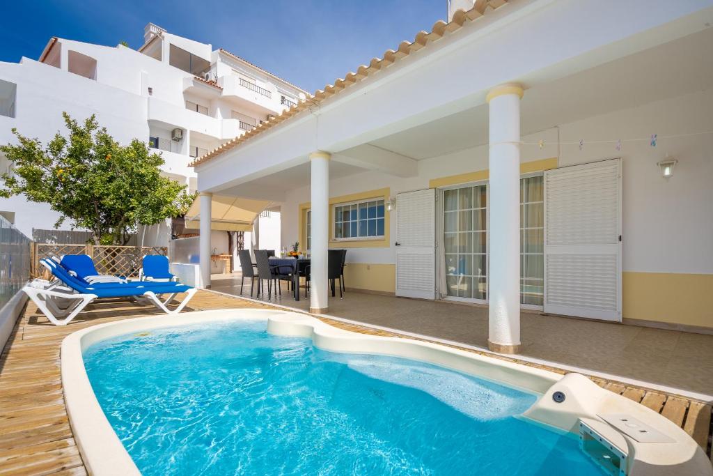 a swimming pool in front of a house at Casa da Amoreira in Alvor