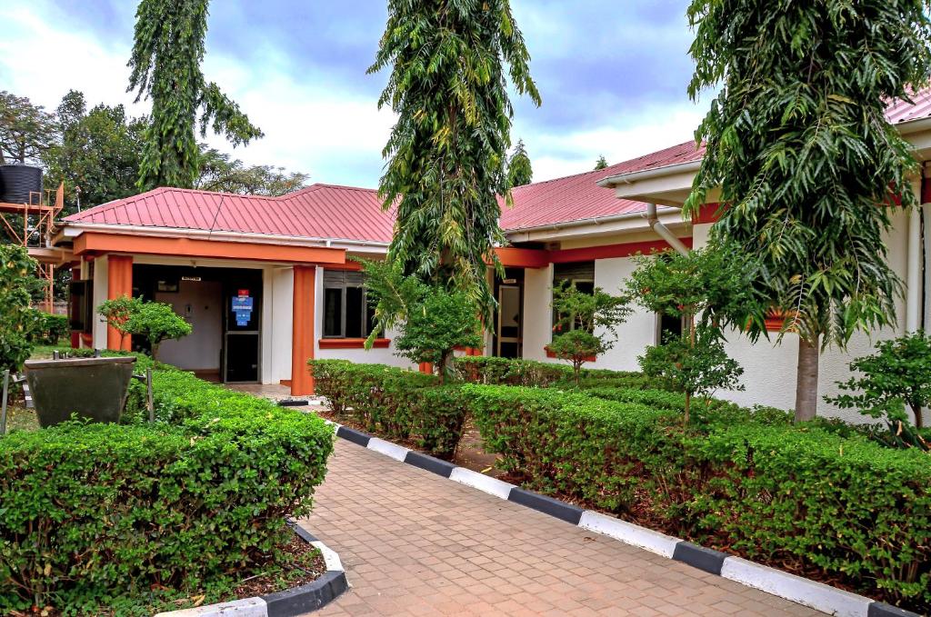 a house with a red roof and some bushes at AKELLO HOTEL in Soroti