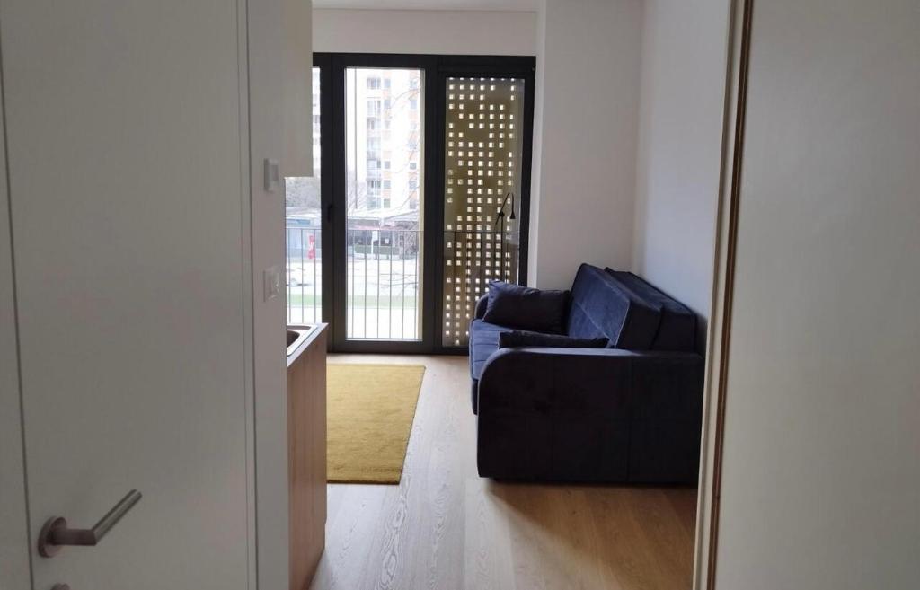 sala de estar con sofá azul y espejo en Modern Studio Apartment, en Liubliana